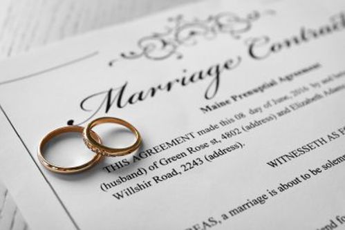 image of an antenuptial contract with wedding rings on top of it